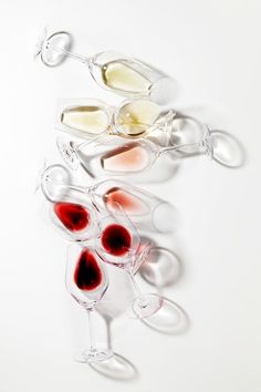 three wine glasses filled with red and white wine