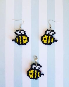 two black and white sheep earrings with yellow numbers on them, hanging from silver earwires