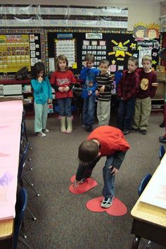 a group of children standing around each other in a classroom