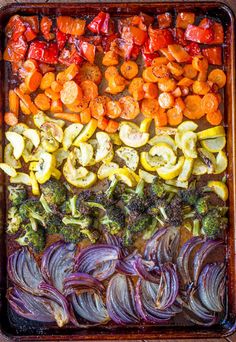 an assortment of vegetables on a baking sheet ready to be cooked in the oven,