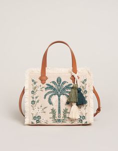 Beautiful embroidery on cotton and jute fabric, fringe and faux leather accents dress our Alljoy Landing Palm Tree Boho Fringe Satchel Crossbody in style while the zipper closure, adjustable & removable crossbody strap and top handles show her smarts. The interior zip plus two slip pockets easily hold the largest i Embroidery Bags Ideas, Recessed Zipper, Leather Embroidery, Poker Set, Jute Fabric, Jute Bag, Boho Fringe, Embroidery Bags, Boho Purses