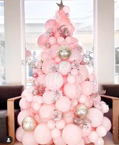 a pink christmas tree made out of balloons