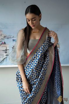 "Quintessential Banarasi art, reinterpreted through a modern-Indian lens for\u00a0a breathtaking\u00a0classic!\u00a0This glorious\u00a0handloom\u00a0piece features\u00a0a contemporary\u00a0geometric\u00a0body, patterned with re-arranged triangles crafted\u00a0in\u00a0gold and silver zari. Effortlessly chic.\n\u00a0\n\n\n Color\u00a0- A\u00a0stunning shade of Midnight Blue\n\n Technique\u00a0- \u00a0Classic handwoven Banarasi art passed down through generations of weavers\n\n\nFabric - Soft as bu Katan Silk, Designer Dresses Indian, Designer Saree, Handloom Saree, Blouse Piece, Traditional Art, Modern Classic, Triangles, Midnight Blue