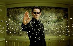 a man in black shirt and sunglasses holding up his hand with bubbles coming out of it