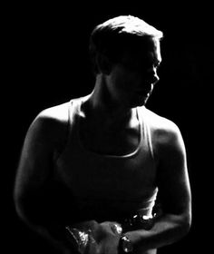 black and white photograph of a woman holding something in her hands while wearing a tank top