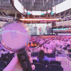 a person holding a video game controller in front of an audience at a sporting event