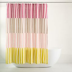 a colorful shower curtain hanging on the side of a bath tub