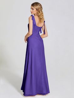 a woman in a long purple dress is looking back at the camera and she has her hand on her hip