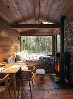 a room with wood floors and a bed in it next to a window that looks out onto the woods