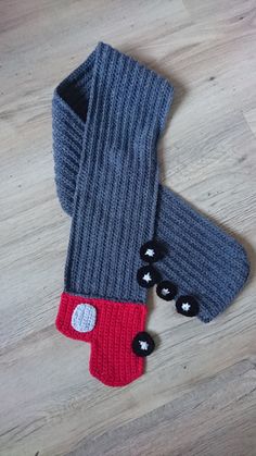 two knitted mittens sitting on top of a wooden floor next to each other