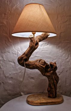 a lamp that is sitting on top of a wooden table next to a white wall