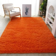 an orange shaggy rug is in front of a white chair and bookcase on the floor