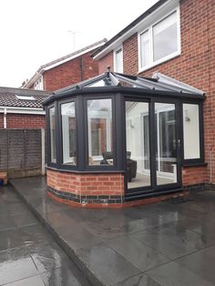 a brick building with a black roof and glass doors on the outside side of it