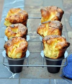 four muffins sitting on top of each other in plastic cups next to a blue towel