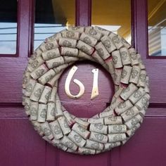 a wreath made out of money sitting on top of a purple door with the letter j in it