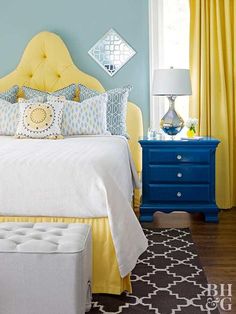 a bedroom with blue walls and yellow curtains