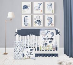 a baby's room with blue and white decor, including an ocean theme crib bedding set