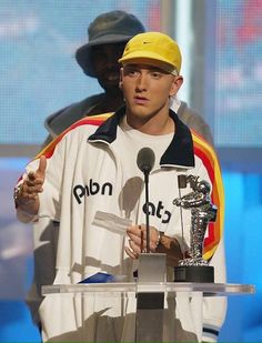 a man giving a thumbs up while standing at a podium with an award in his hand