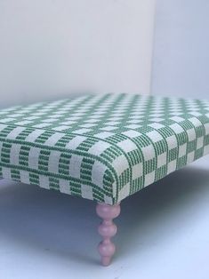 a green and white checkered bench with pink legs