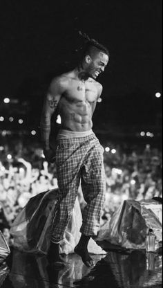 a shirtless man standing on top of a stage