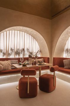 an elegant dining room with orange chairs and round windows