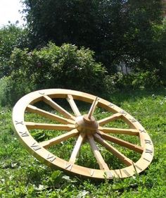 a large wooden wheel sitting in the grass