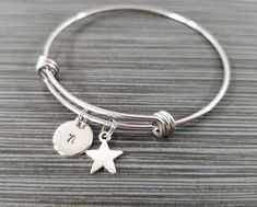 Personalized Antique Silver Star Bangle Bracelet!  A star charm on an expandable bangle bracelet makes the perfect gift for you or your best friend.The star bracelet charm is made from zinc alloy and measures 12 mm by 9 mm.  The bangle bracelet is high quality stainless steel and fits a wrist sized 6-8".  The star bangle bracelet is personalized with a .5" silver plated disc stamped with the initial of your choice.  The charm and initial disc are connected to the bangle with sturdy split rings t Adjustable Star Charm Bracelet, Adjustable Stretch Bracelet With Star Charm As Gift, Silver Star Bracelet For Friendship, Adjustable Star Charm Bracelet For Friendship, Silver Bracelet With Star Charm For Friendship, Silver Friendship Bracelets With Star Charm, Silver Bracelets With Star Charm For Friendship, Adjustable Charm Bracelet With Star Charm, Adjustable Star-shaped Stretch Bracelet Gift