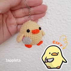 a small crocheted chick keychain hanging from a persons hand