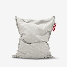 a grey pillow sitting on top of a white floor