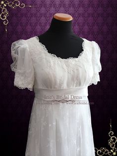 a white dress on a mannequin dummy with purple wall in the back ground