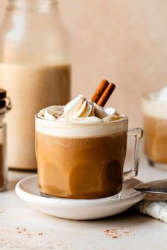 there is a cup of hot chocolate with whipped cream and cinnamon sticks in the mug