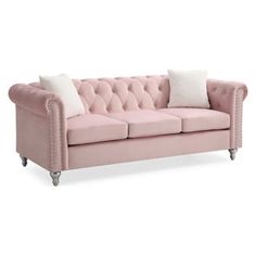 a pink couch with white pillows on it