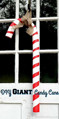 a candy cane hanging from the side of a white door that says, diy giant candy canes