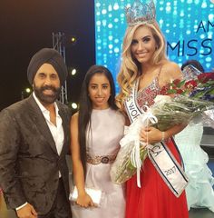 two women and a man standing next to each other in front of a miss america sign