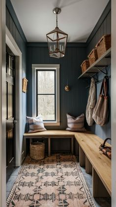 an entryway with a bench, rug and baskets on the shelf next to it