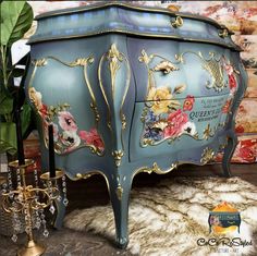 an ornately painted blue chest with gold trimmings and flowers on the drawers