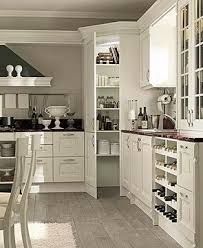 a kitchen with white cabinets and wooden floors