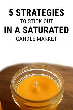 a candle sitting on top of a wooden table with text overlay that reads 5 strategies to stick out in a saturated candle market