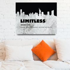 a bed with white sheets and pillows in front of a wall mounted canvas that says limitless