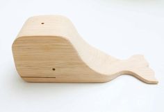 a wooden whale toy on a white surface