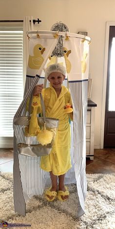 a little boy dressed up in a bathrobe with rubber ducks on his feet