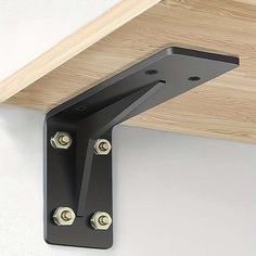 a close up of a wooden shelf with two metal brackets on the top and bottom