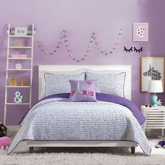 a bedroom with purple walls and bedding in the middle is decorated with white shelving