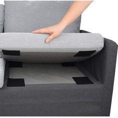 a person is holding the back end of a couch