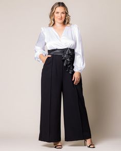 Opt for one-and-done elegance with the Refined Satin Jumpsuit. The smoothness of satin meets the refined structure of ponte. This special occasion pantsuit features a surplice bodice, ruching at the waistband, pockets, back zipper, long lantern sleeves and a flattering pintuck along the pant legs. An artfully folded sashay at the waist provides a hint of drama. An ideal option for the glam wedding guest or elegant mother of the bride or groom. This black jumpsuit is perfect for holiday gathering Jumpsuit And Cardigan, Elegant Mother Of The Bride, Chic Cardigan, Formal Jumpsuit, Satin Jumpsuit, Black Tie Affair, Evening Gown Dresses, Jumpsuit Party, Black Tie Wedding