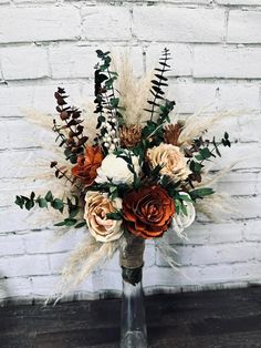 a vase filled with flowers on top of a wooden table next to a brick wall