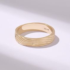 a close up of a gold ring on a white surface