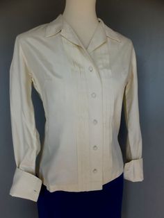 "A classic style blouse that will make a fabulous addition to a professional girl's working wardrobe. Tuxedo style. Condition:  Excellent.    French cuffs.  Off white, ivory in color.  Really good quality fabric.  No fabric label.  Feels like it could be polished cotton or something better.  Feels great. Please keep in mind that all monitors show color differently and that the color may not be exact. Bust:  up to 38\" Waist:  32 Shoulder to shoulder:  15 Sleeve:  21 Length:  23-1/2, measuring fr Working Wardrobe, Tuxedo Style, Fabric Labels, Vintage Blouse, Vintage Nature, Style Blouse, Blouse Vintage, Cotton Blouses, Womens Clothing Tops