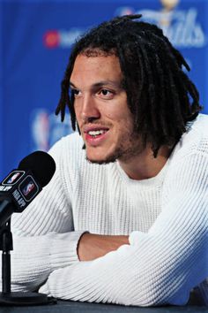 a man with dreadlocks sitting in front of a microphone at a press conference