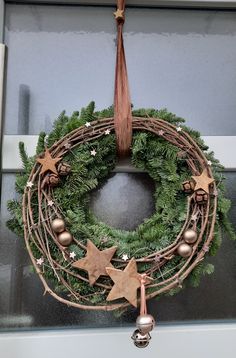 a christmas wreath hanging from the side of a door with ornaments around it and star decorations